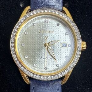 Citizen Eco Drive Gold Tone Watch Crystal Bezel Blue Strap Date